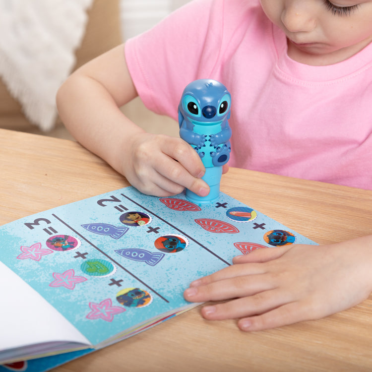 A kid playing with The Melissa & Doug Sticker WOW! Disney Stitch Bundle with 2 Activity Pads and 500 Stickers - For Ages 3+