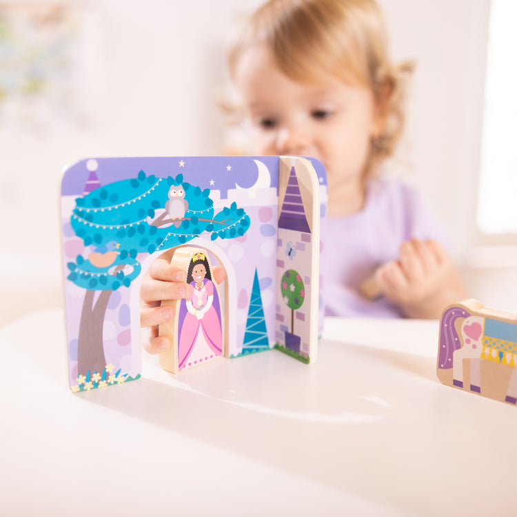 A kid playing with The Wooden Fairy Tale Play Set