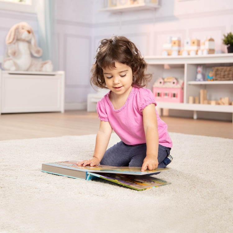 A kid playing with The Melissa & Doug Children's Book - Poke-a-Dot: The Wheels on the Bus Wild Safari (Board Book with Buttons to Pop)