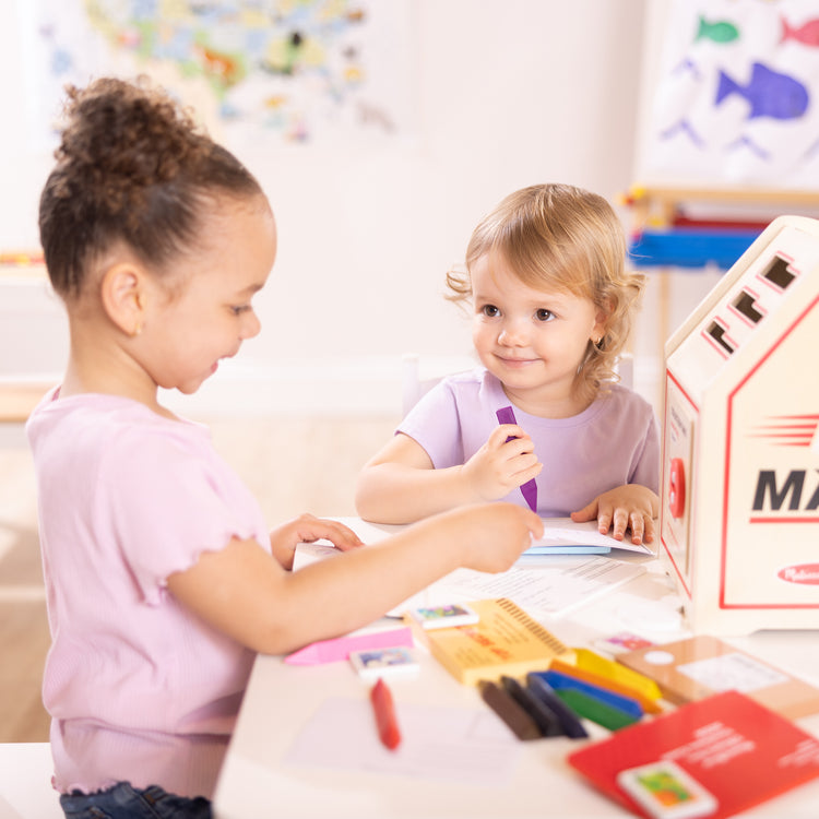 A kid playing with The Stamp and Sort Mailbox Play Set