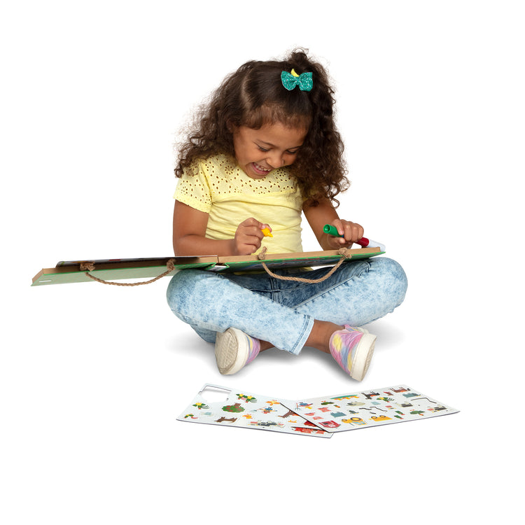 A child on white background with The Melissa & Doug Natural Play: Play, Draw, Create Reusable Drawing & Magnet Kit – Farm (38 Magnets, 5 Dry-Erase Markers)