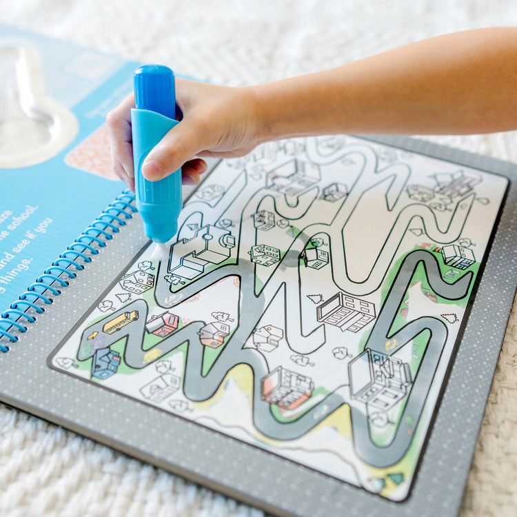 A kid playing with The Melissa & Doug On the Go Water Wow! Reusable Water-Reveal Deluxe Activity Pad – Around Town