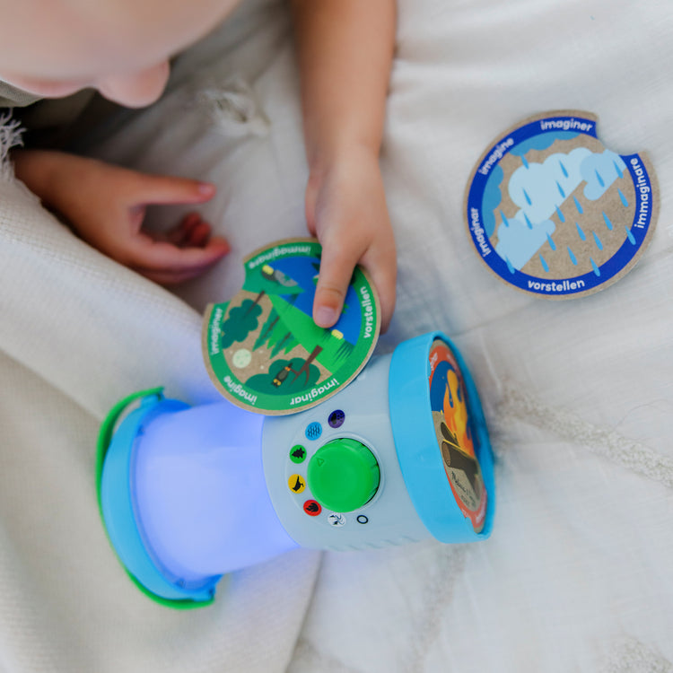A kid playing with The Melissa & Doug Let’s Explore™ Light & Sound Camping Lantern Play Set