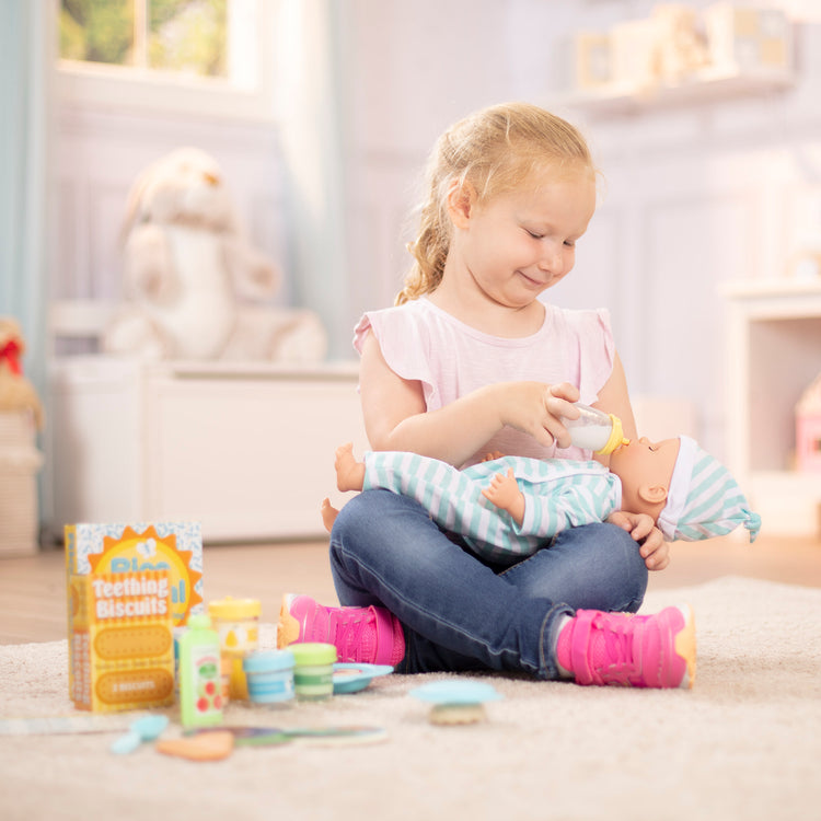 A kid playing with The Melissa & Doug Mine to Love Mealtime Play Set for Dolls with Bottle, Pretend Baby Food Jars, Snack Pouch, More (24 pcs)