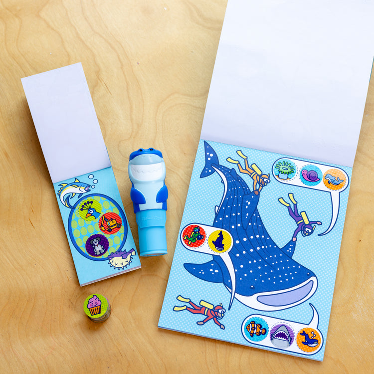 A playroom scene with The Melissa & Doug Sticker WOW!™ Shark Bundle: 24-Page Activity Pad, Sticker Stamper, 500 Stickers, Mini Pad, Arts and Crafts Fidget Toy Collectible Character