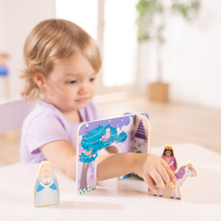 A kid playing with The Wooden Fairy Tale Play Set