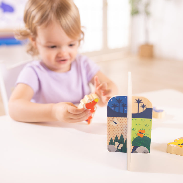 A kid playing with The Wooden Dinosaurs Play Set