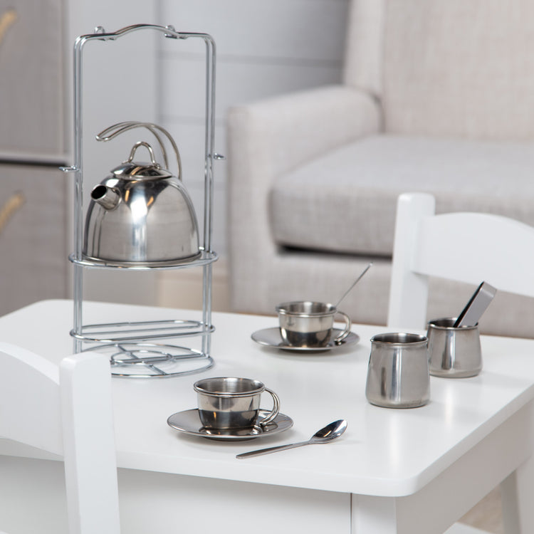 A playroom scene with The Melissa & Doug Stainless Steel Pretend Play Tea Set with Storage Rack for Kids (11 pcs)