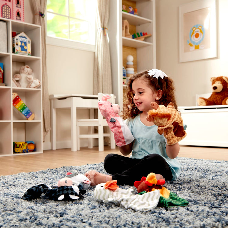 A kid playing with the Melissa & Doug Barn Buddies Hand Puppets, Set of 6 (Cow, Sheep, Horse, Duck, Chicken, Pig)