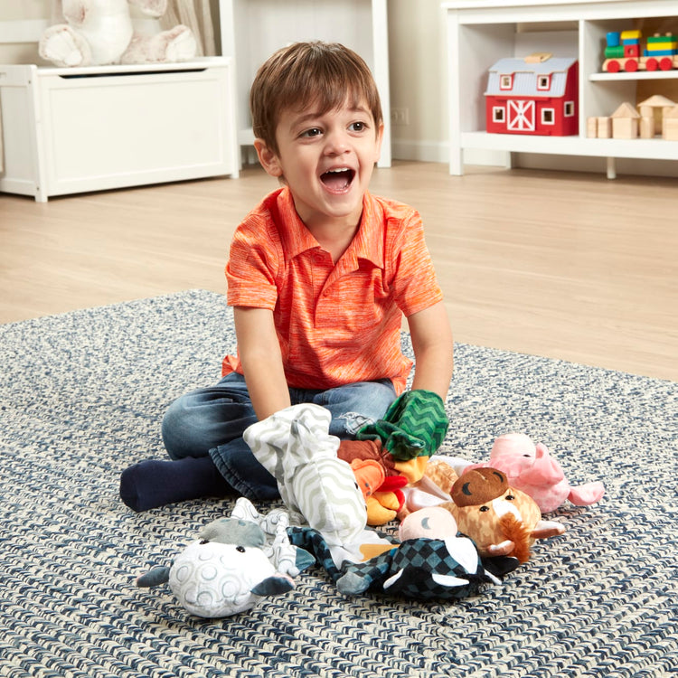 A kid playing with the Melissa & Doug Barn Buddies Hand Puppets, Set of 6 (Cow, Sheep, Horse, Duck, Chicken, Pig)
