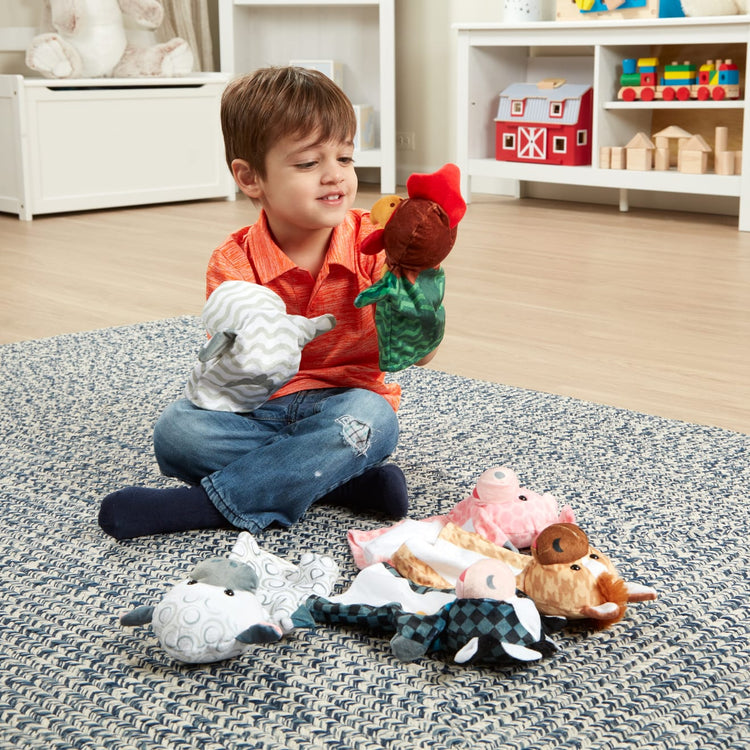 A kid playing with the Melissa & Doug Barn Buddies Hand Puppets, Set of 6 (Cow, Sheep, Horse, Duck, Chicken, Pig)