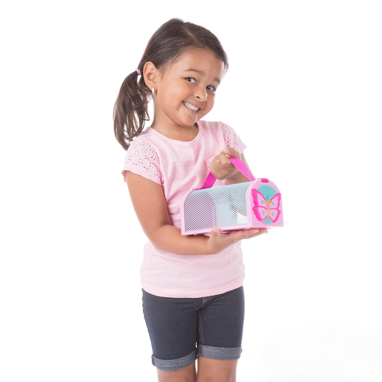 A child on white background with the Melissa & Doug Sunny Patch Cutie Pie Butterfly Bug House Toy With Carrying Handle and Easy-Access Door