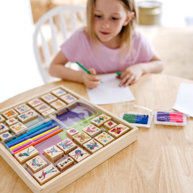 The front of the box for the Melissa & Doug Deluxe Wooden Stamp and Coloring Set – Fairy Tale (30 Stamps, 6 Markers, 2 Durable 2-Color Stamp Pads)