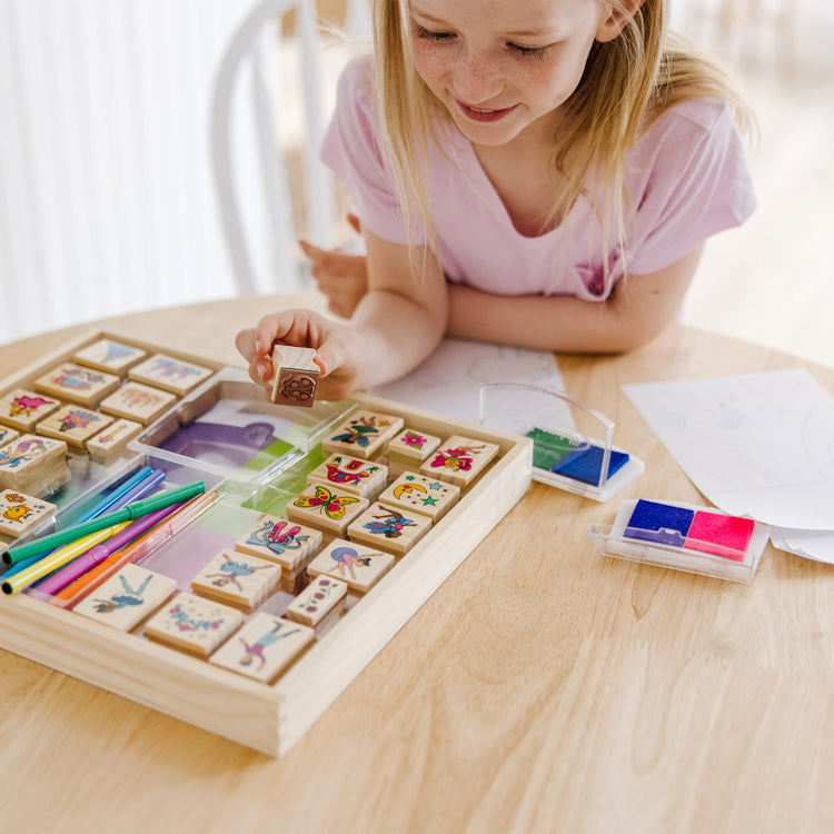 The front of the box for the Melissa & Doug Deluxe Wooden Stamp and Coloring Set – Fairy Tale (30 Stamps, 6 Markers, 2 Durable 2-Color Stamp Pads)