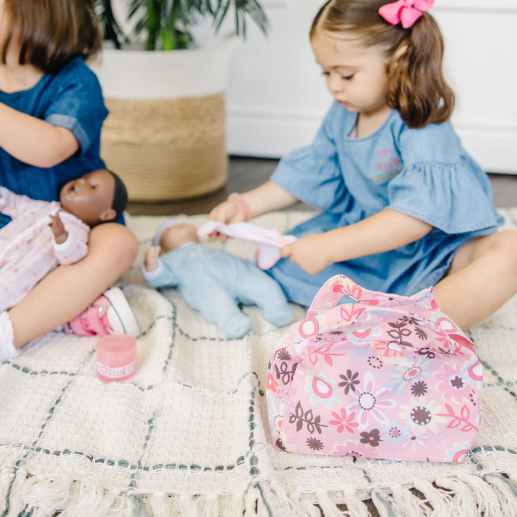 A kid playing with the Melissa & Doug Mine to Love Doll Diaper Changing Set With Accessories (7 pcs)