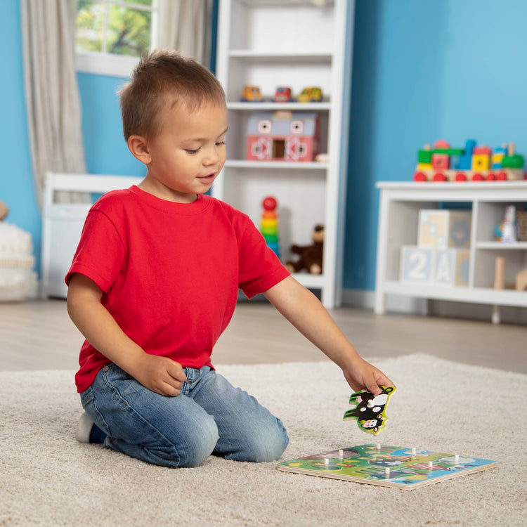 A kid playing with the Melissa & Doug Farm Wooden Peg Puzzle (8 pcs)