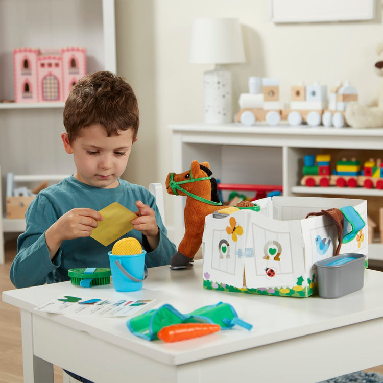A kid playing with the Melissa & Doug Feed & Groom Horse Care Play Set With Plush Stuffed Animal (23 pcs)