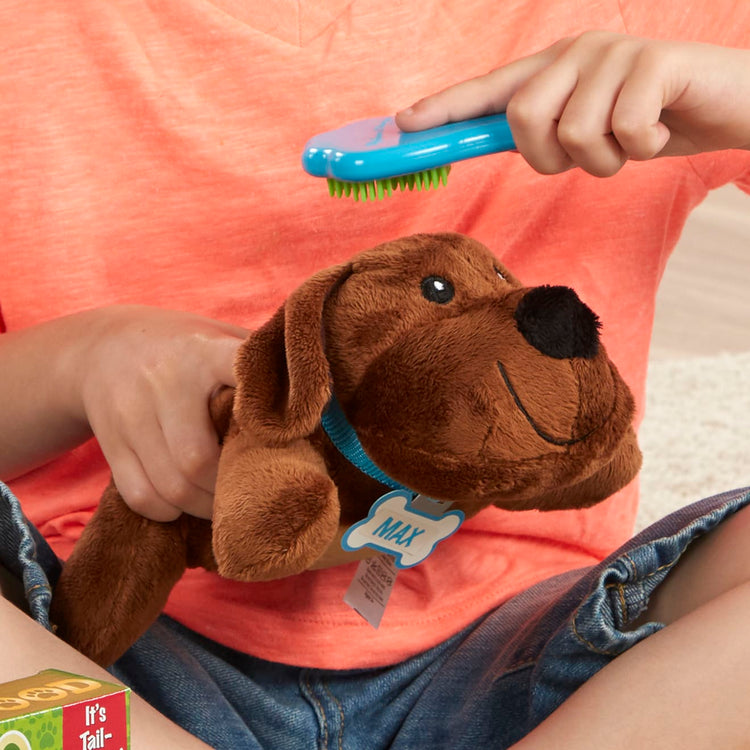 A kid playing with the Melissa & Doug Feeding and Grooming Pet Care Play Set