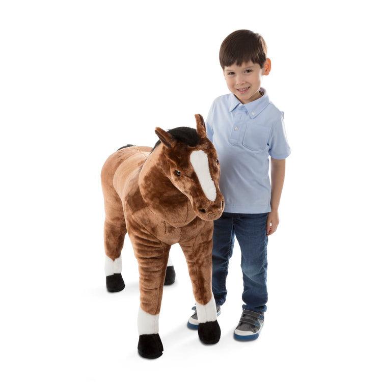 A child on white background with the Melissa & Doug Giant Horse - Lifelike Stuffed Animal (nearly 3 feet tall)