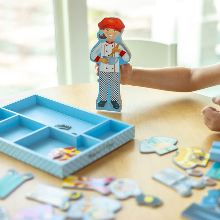A kid playing with the Melissa & Doug Julia Magnetic Dress-Up Wooden Doll Pretend Play Set (25+ pcs)