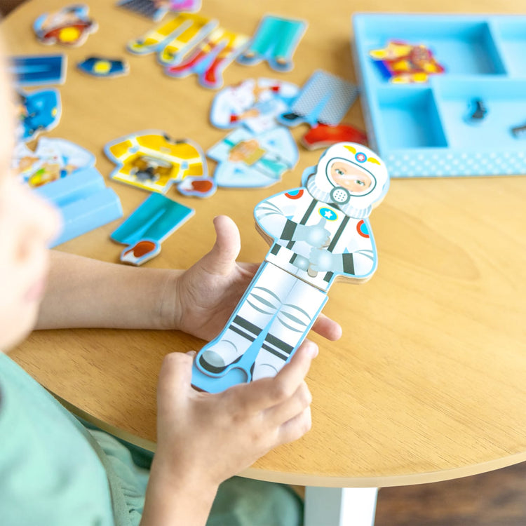 A kid playing with the Melissa & Doug Julia Magnetic Dress-Up Wooden Doll Pretend Play Set (25+ pcs)