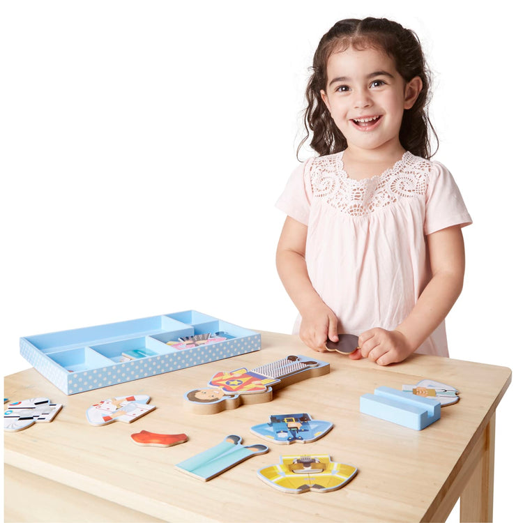 A child on white background with the Melissa & Doug Julia Magnetic Dress-Up Wooden Doll Pretend Play Set (25+ pcs)