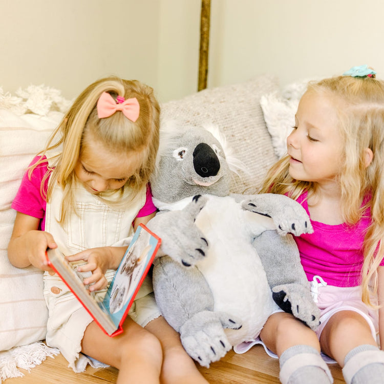 A kid playing with the Melissa & Doug Lifelike Plush Koala Stuffed Animal (13.5W x 14H x 12D in)