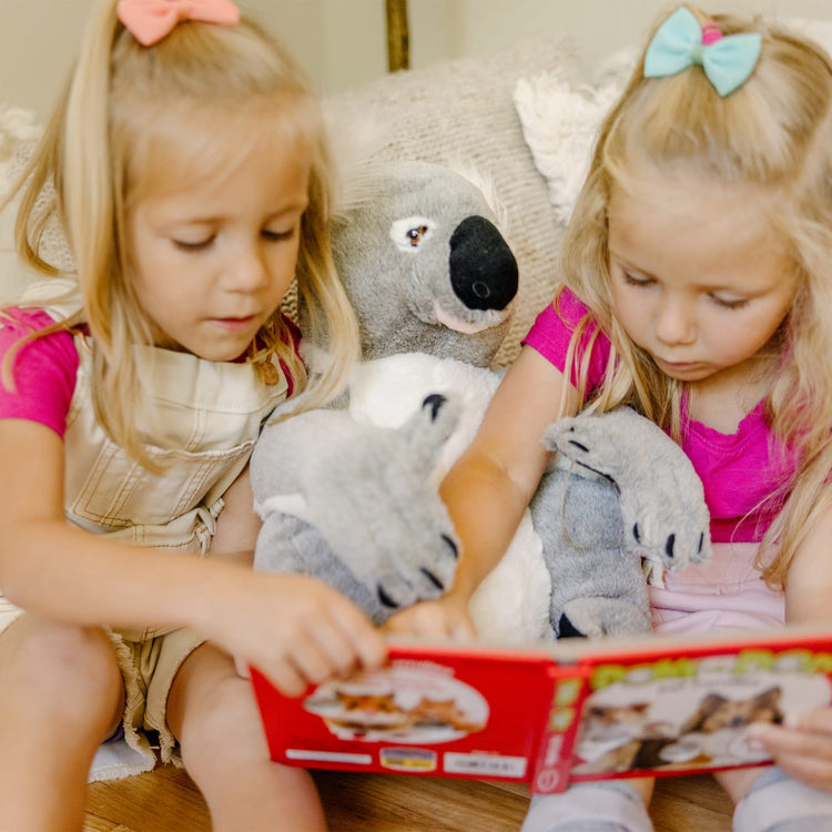A kid playing with the Melissa & Doug Lifelike Plush Koala Stuffed Animal (13.5W x 14H x 12D in)