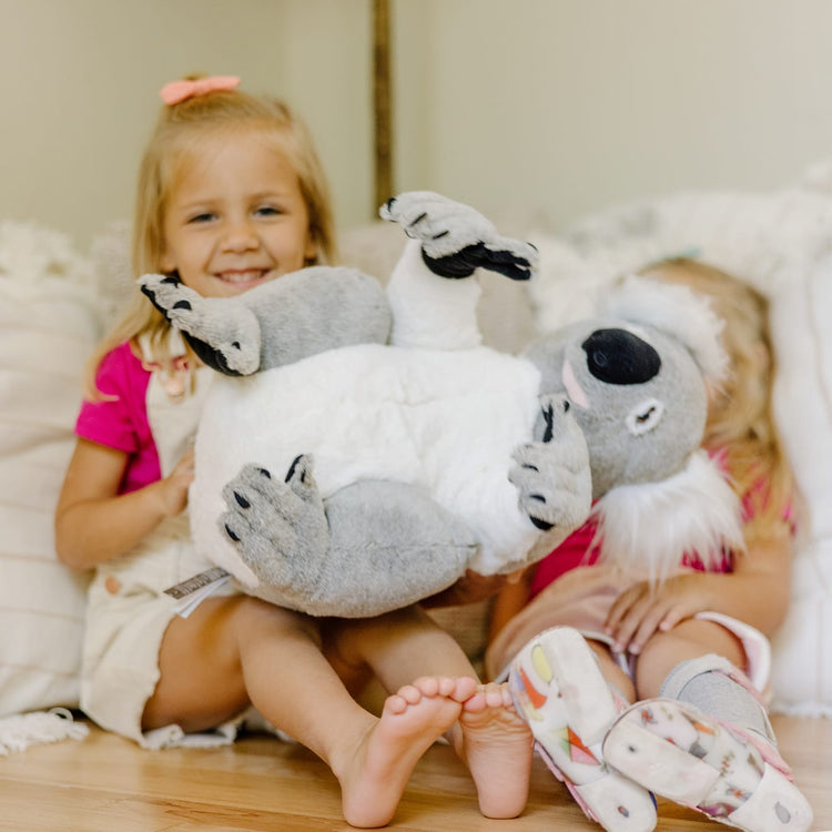 A kid playing with the Melissa & Doug Lifelike Plush Koala Stuffed Animal (13.5W x 14H x 12D in)
