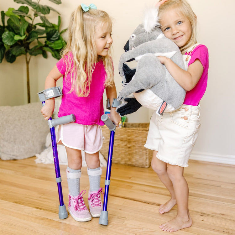 A kid playing with the Melissa & Doug Lifelike Plush Koala Stuffed Animal (13.5W x 14H x 12D in)