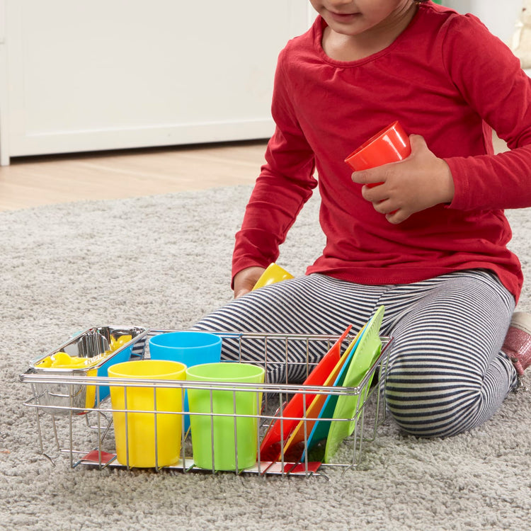A kid playing with the Melissa & Doug Wash and Dry Dish Set - 24 Pieces