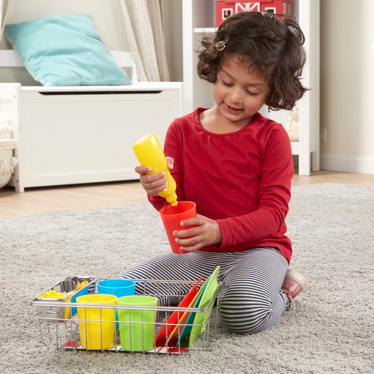 A kid playing with the Melissa & Doug Wash and Dry Dish Set - 24 Pieces