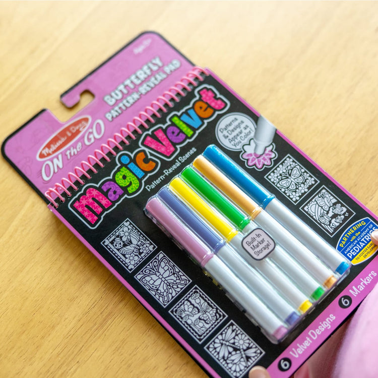 The front of the box for the Melissa & Doug On the Go Magic Velvet Pattern-Reveal Scenes Activity Kit - 6 Coloring Boards, 6 Markers