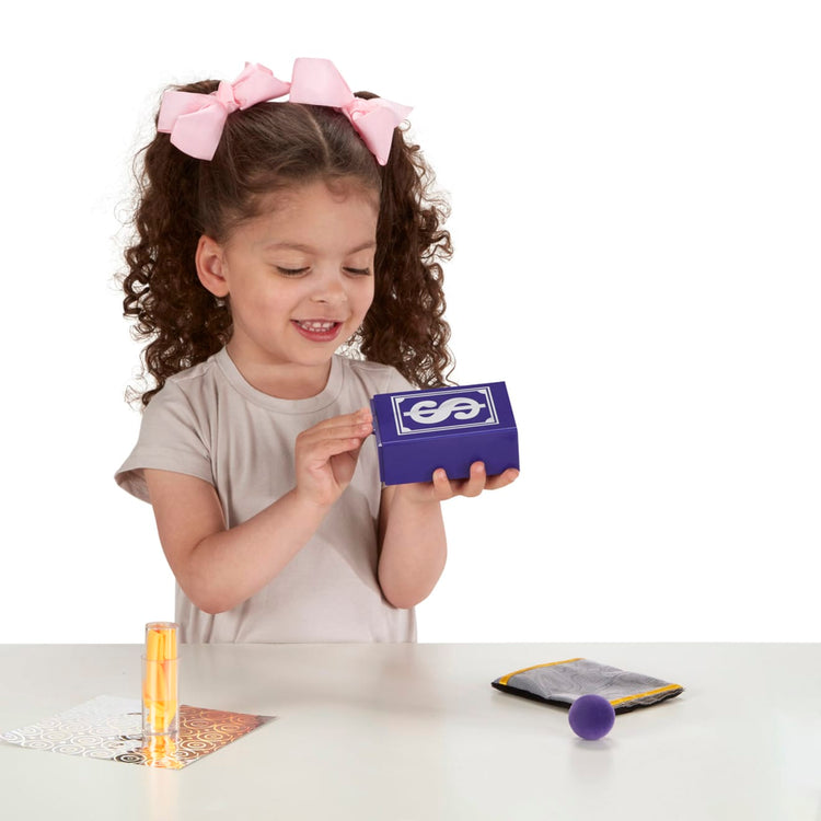 A child on white background with the Melissa & Doug Magic in a Snap! Hocus Pocus Collection Magic Tricks Set (12 pcs)