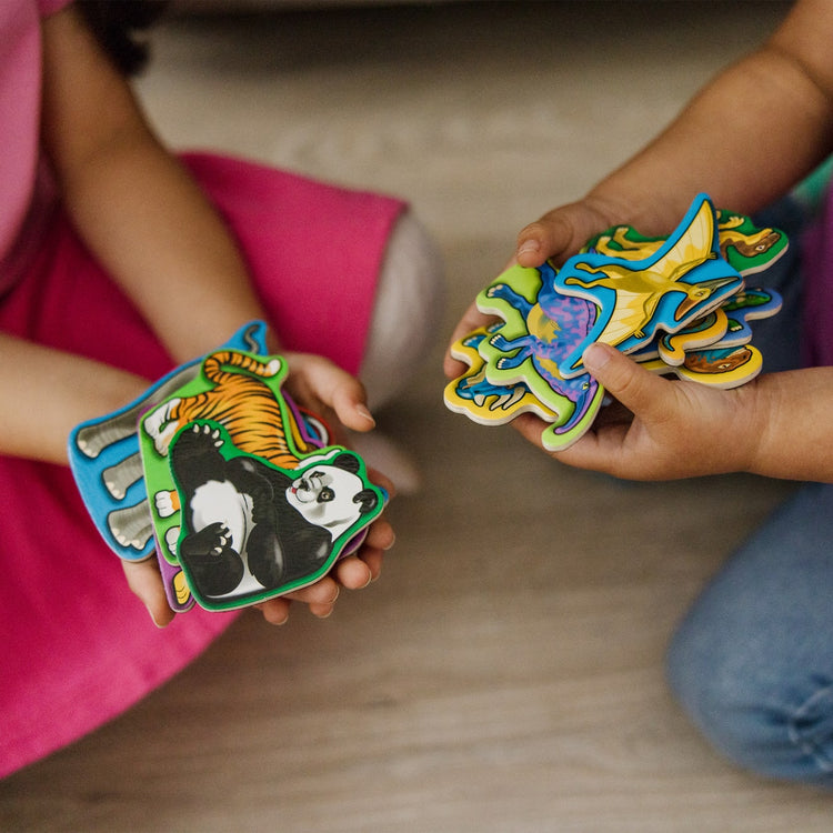 A kid playing with the Melissa & Doug Wooden Magnets Set - Animals and Dinosaurs With 40 Wooden Magnets