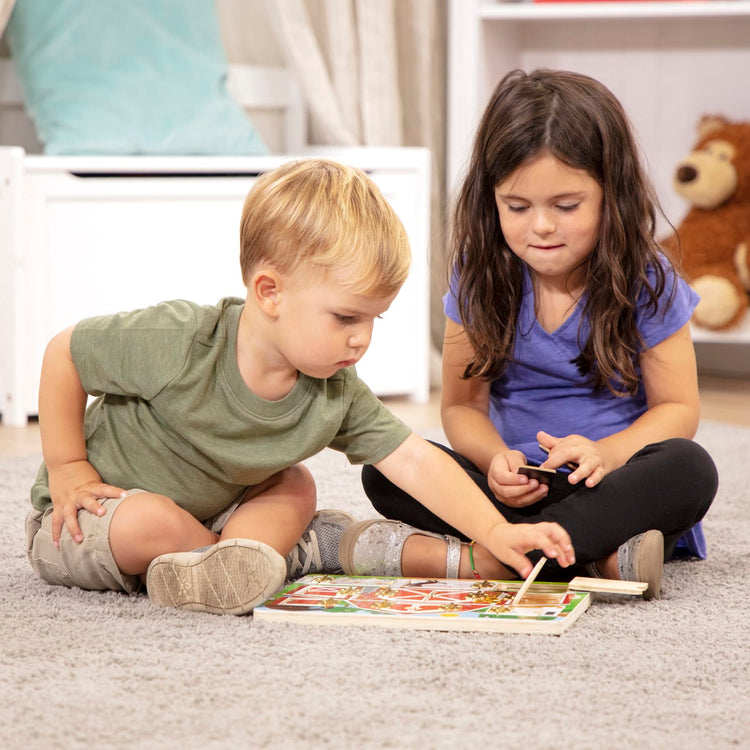 A kid playing with the Melissa & Doug Hide and Seek Farm Wooden Activity Board With Barnyard Animal Magnets