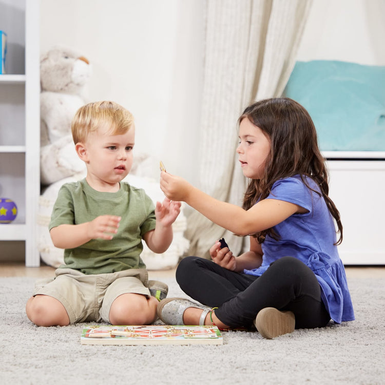 A kid playing with the Melissa & Doug Hide and Seek Farm Wooden Activity Board With Barnyard Animal Magnets