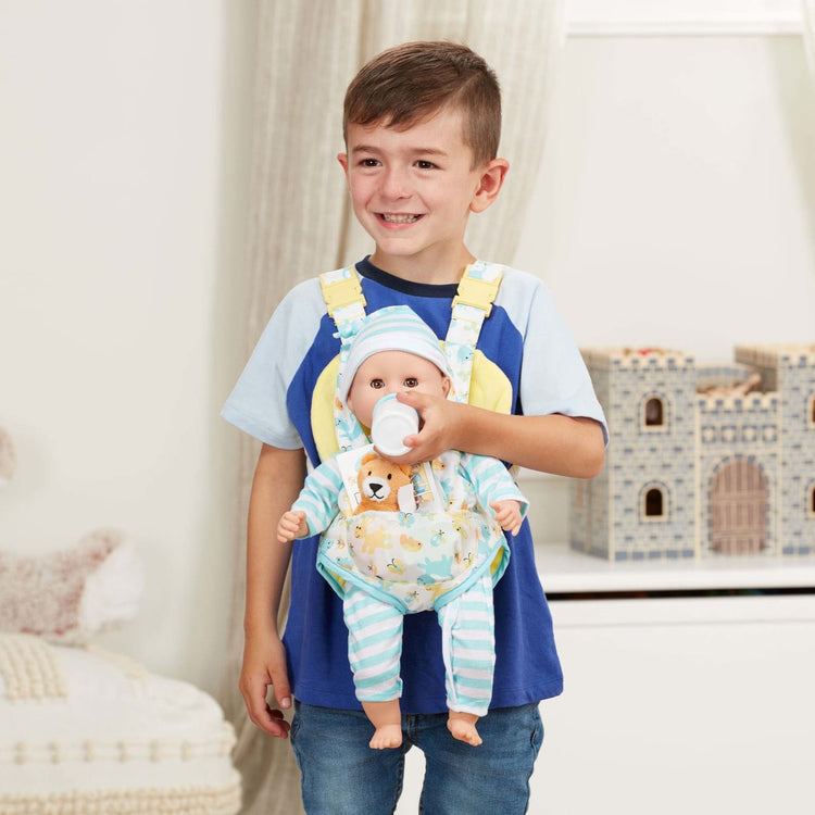 A kid playing with the Melissa & Doug Mine to Love Carrier Play Set for Baby Dolls with Toy Bear, Bottle, Rattle, Activity Card
