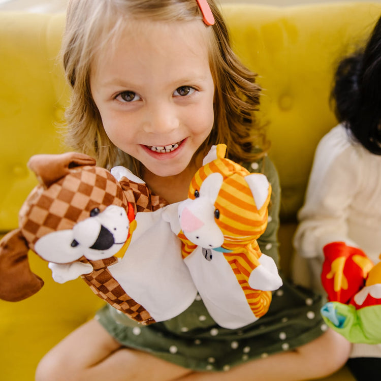 A kid playing with the Melissa & Doug Playful Pets Hand Puppets (Set of 4)